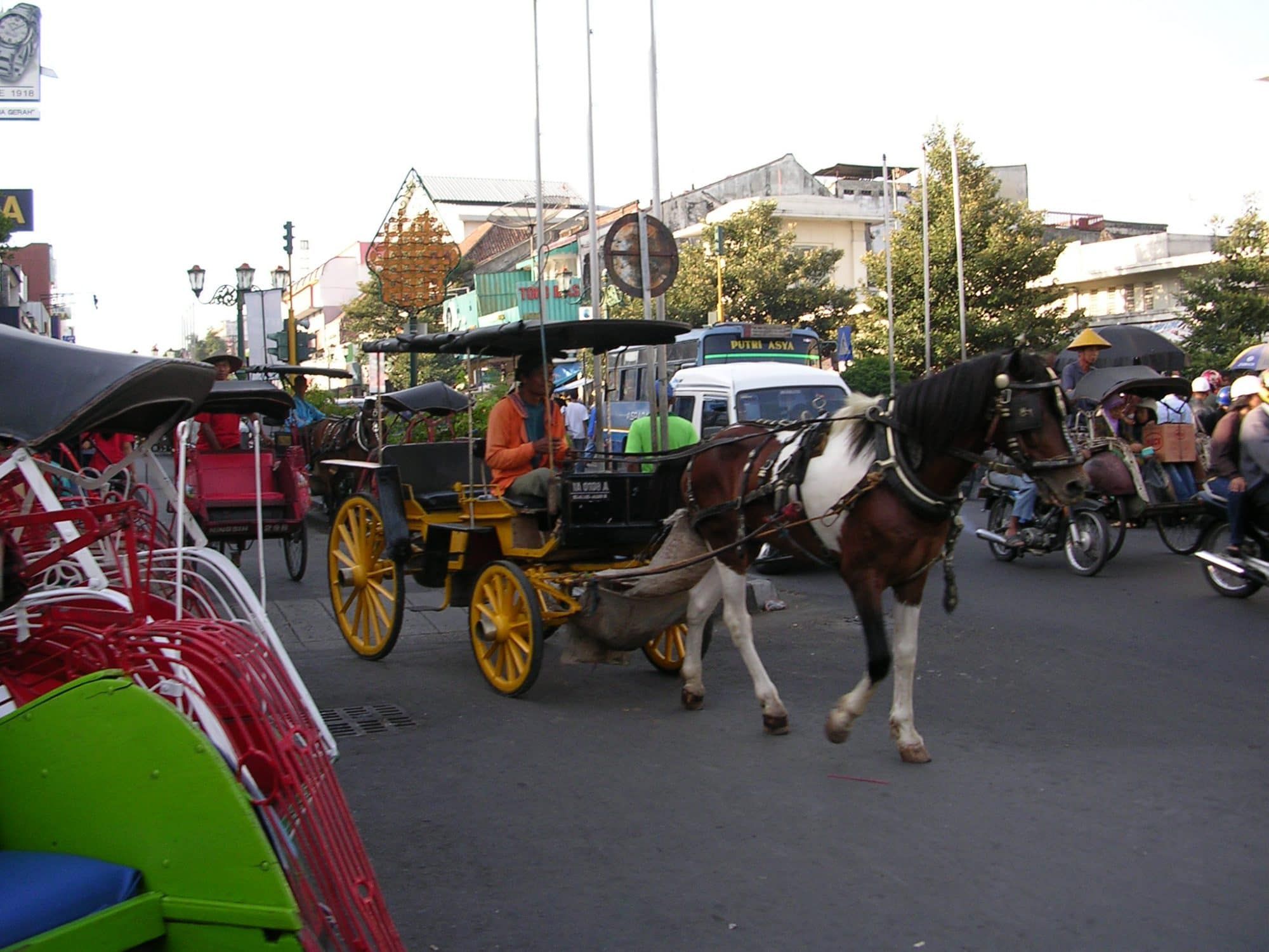 An andong (horse and carriage) moving through the bustle of Malioboro shopping street — the living sultan's city of Yogyakarta, about 21 km from the villa
