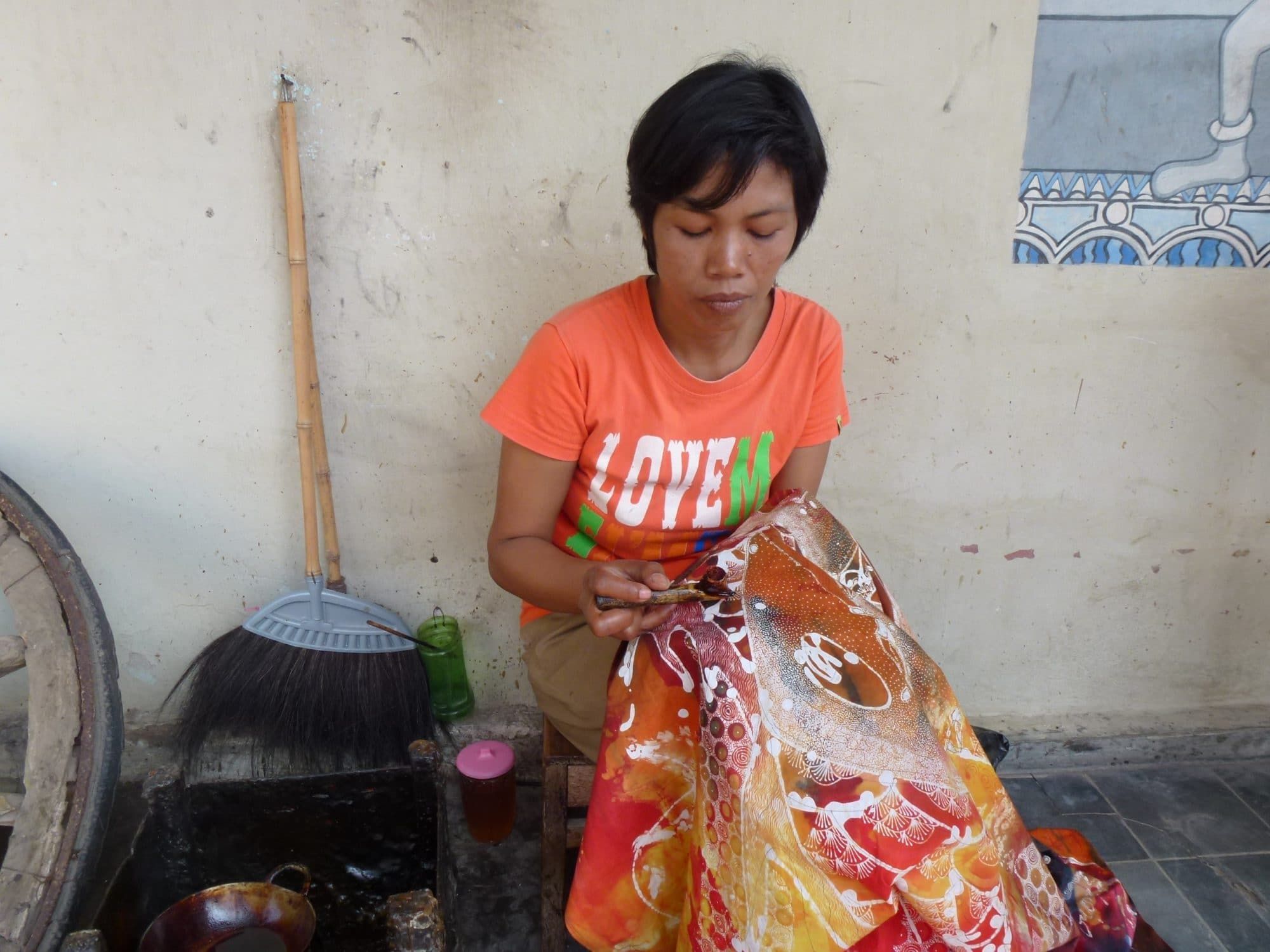 Batik maker applying wax to cloth, layer by layer, in a workshop behind the Kraton, Yogyakarta