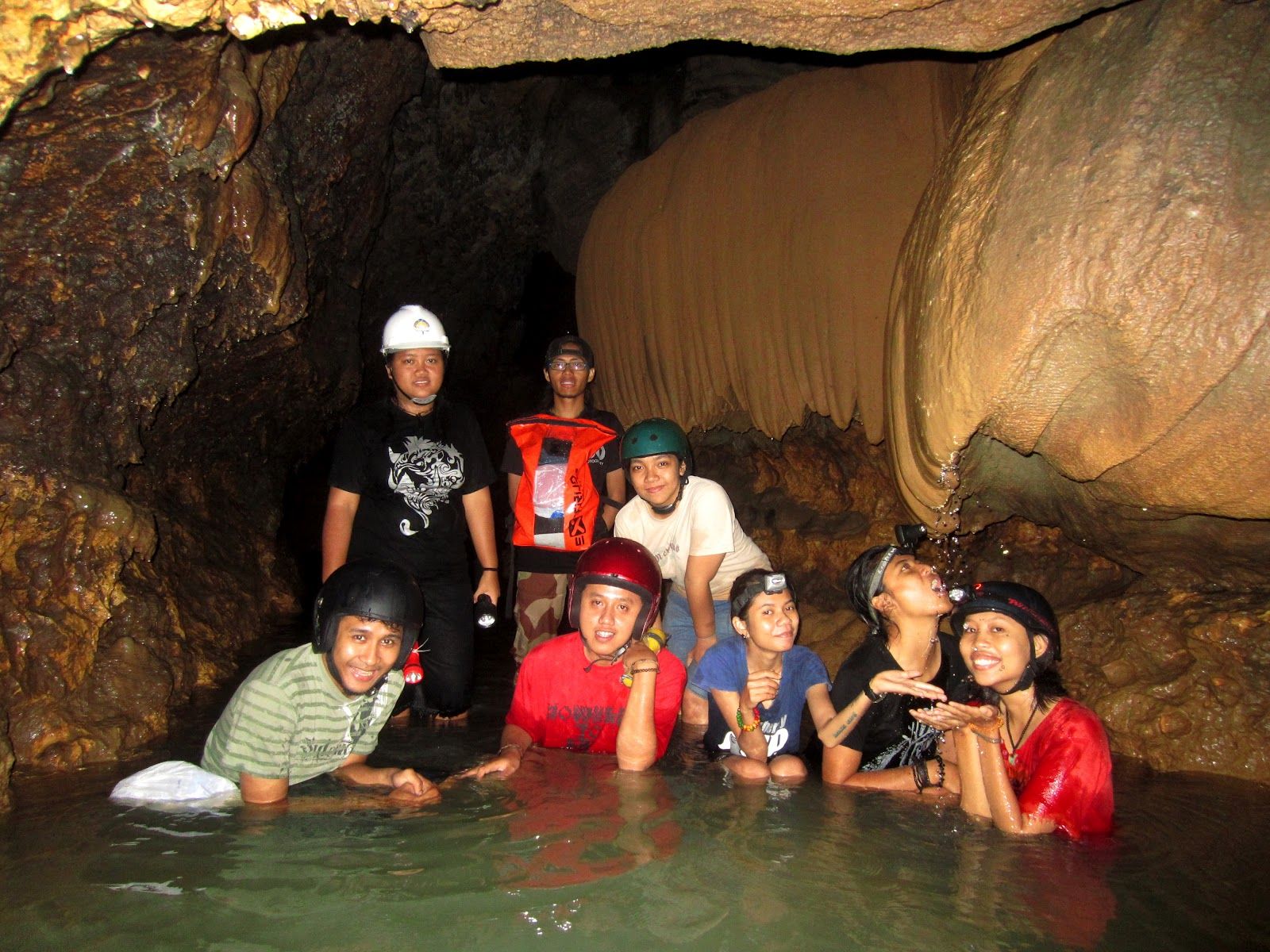 guests with helmet and headlamp in Cerme Cave's underground river — day trip from Villa Tanen