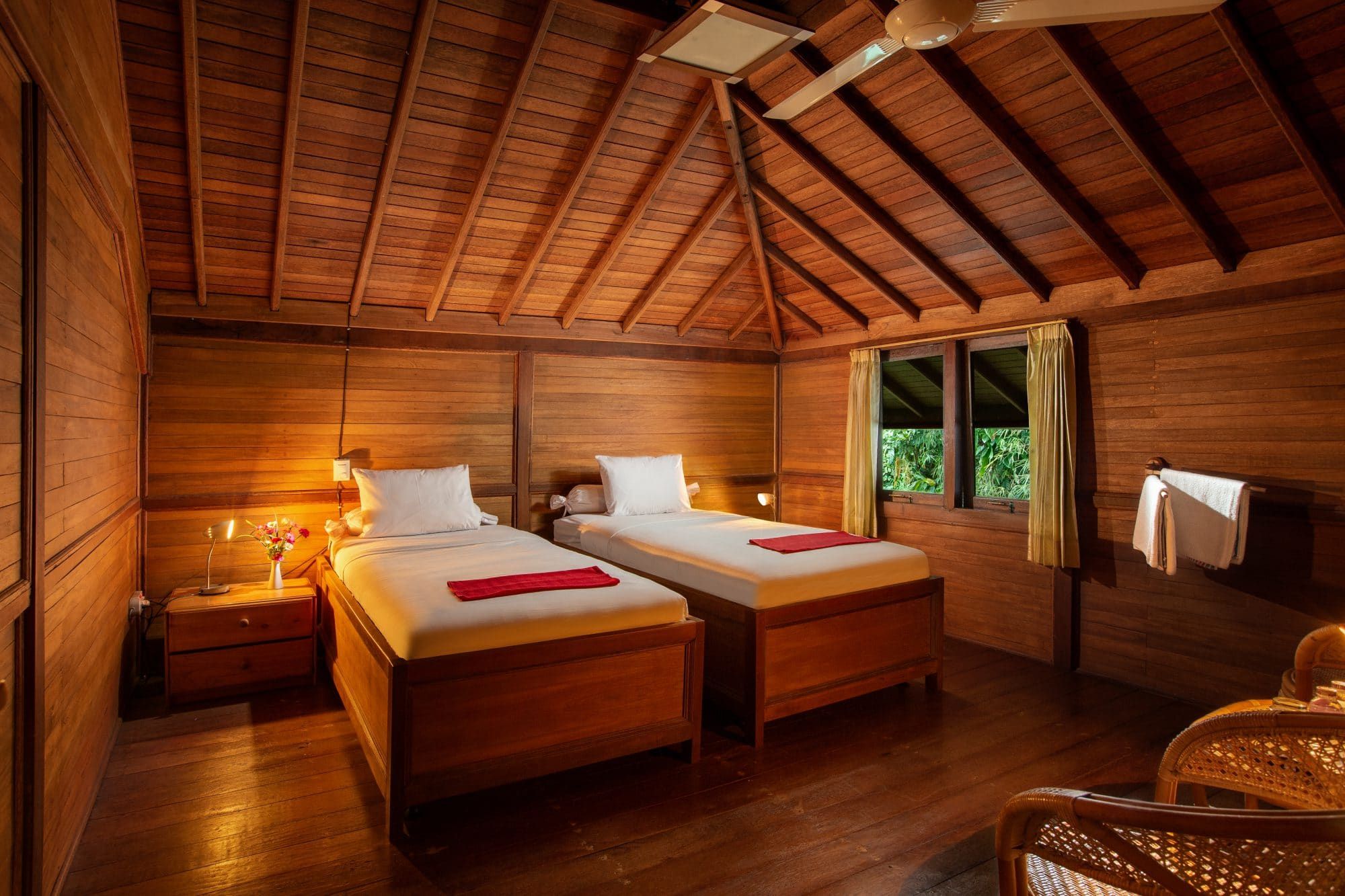 First-floor room at Villa Tanen — twin beds, warm wooden ceiling with exposed beams