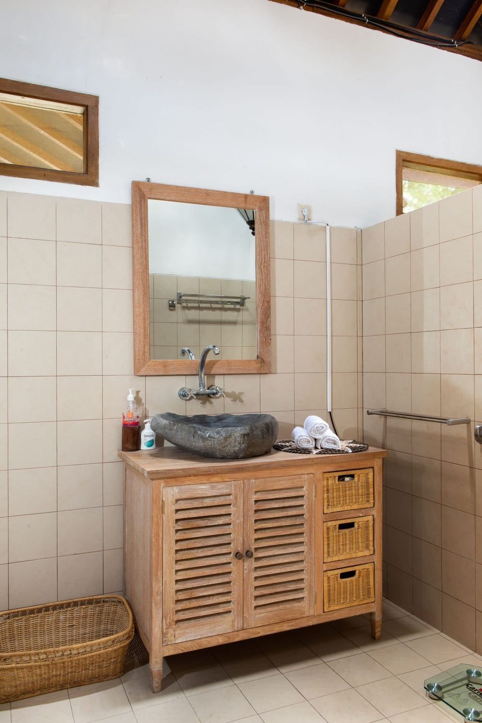 Bathroom at Villa Tanen with stone vessel sink on wooden cabinet, mirror and walk-in shower