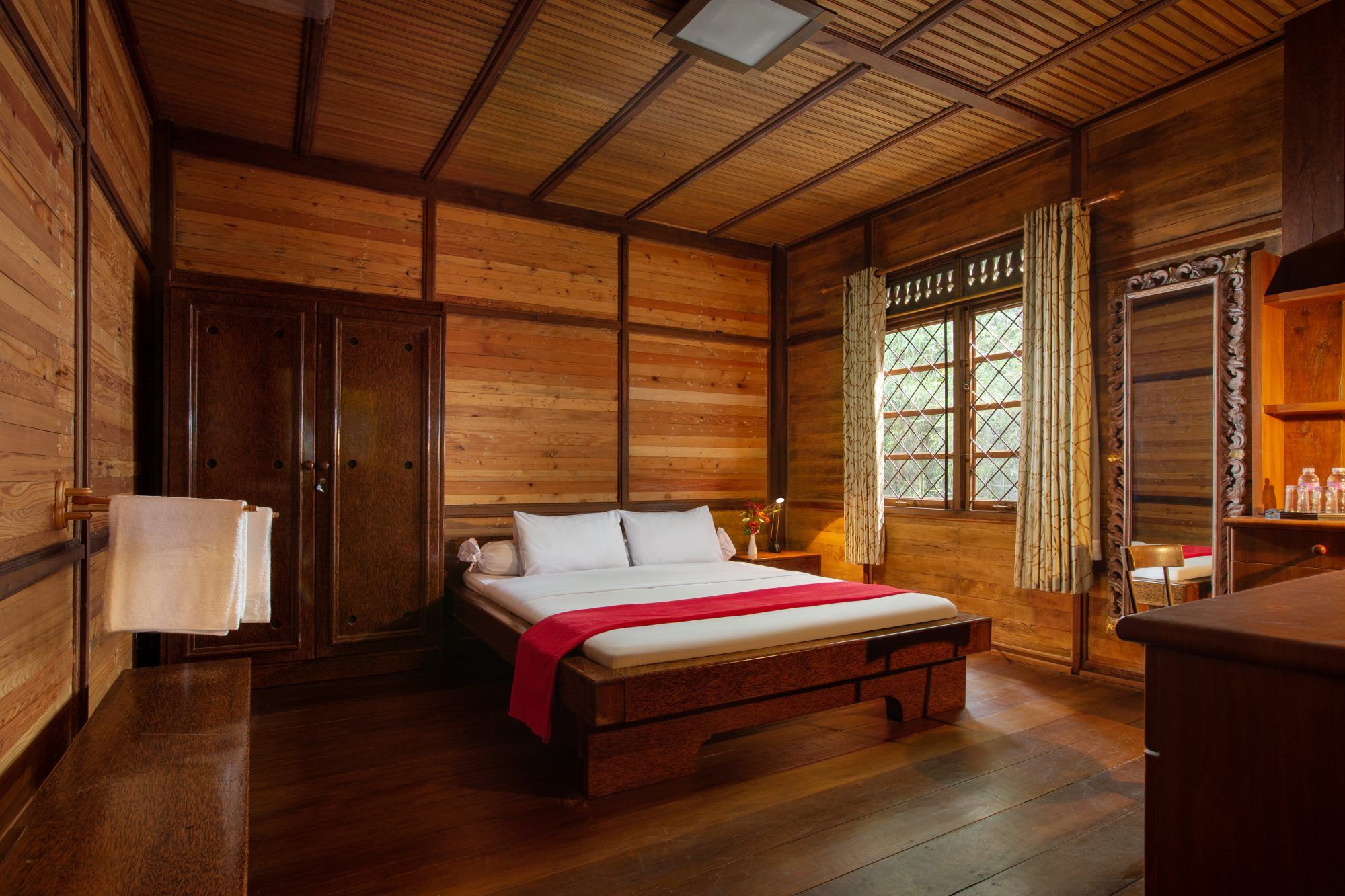 Double room with wooden walls and double bed, warm bedside lamps