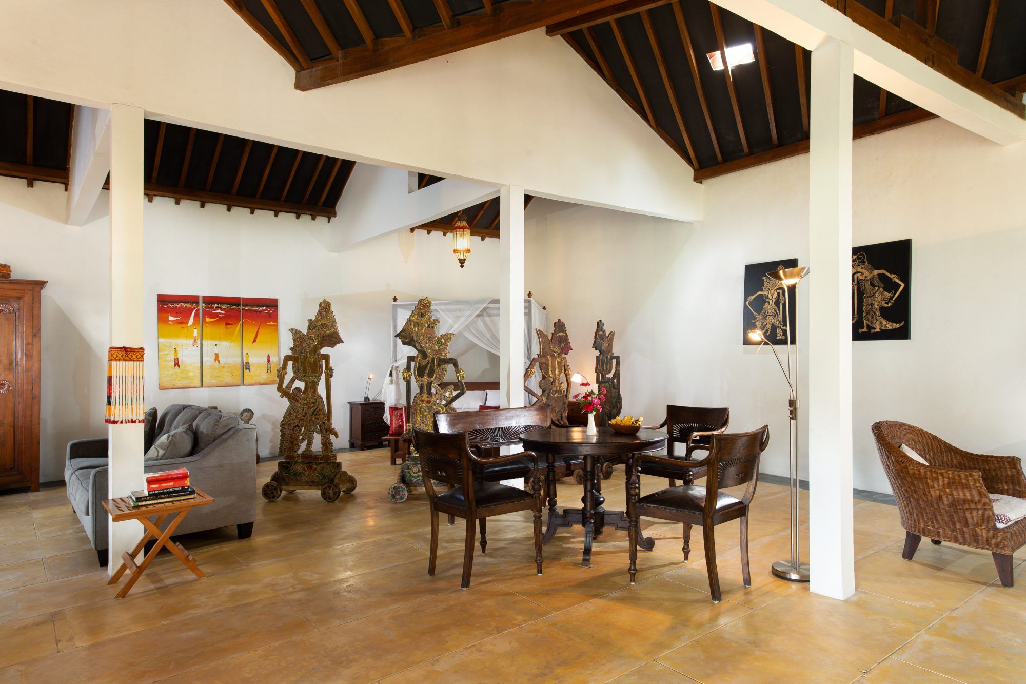 Interior of Rumah Pojok studio — dining area, art objects and high roof